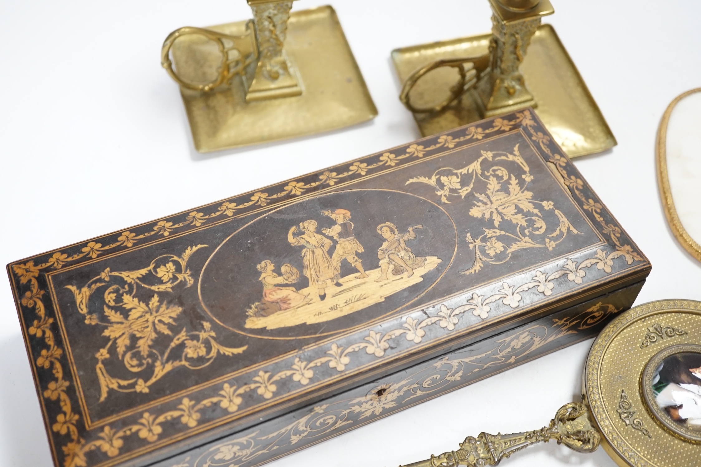 An inlaid Sorrento style box, a gilt hand mirror with enamel cartouche, a pair of brass candle holders and another hand mirror, box 30cm wide